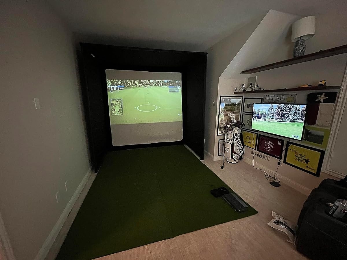 A finished home golf simulator room with an enclosure, impact screen and turf floor